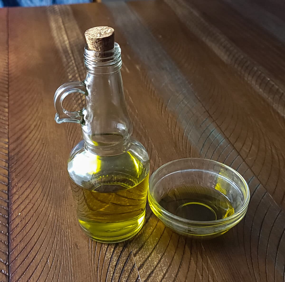olive oil in a dipping saucer and a glass bottle
